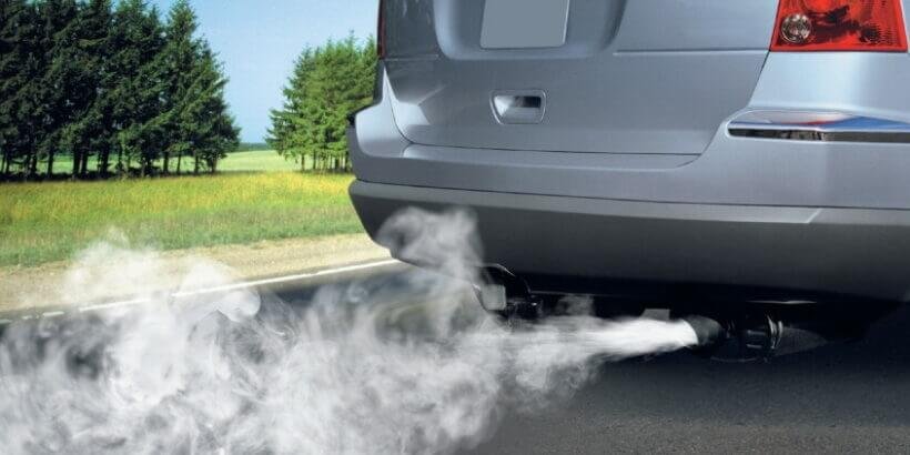 Humo azul saliendo del escape de un carro indicando motor con anillos o guías de válvulas desgastadas