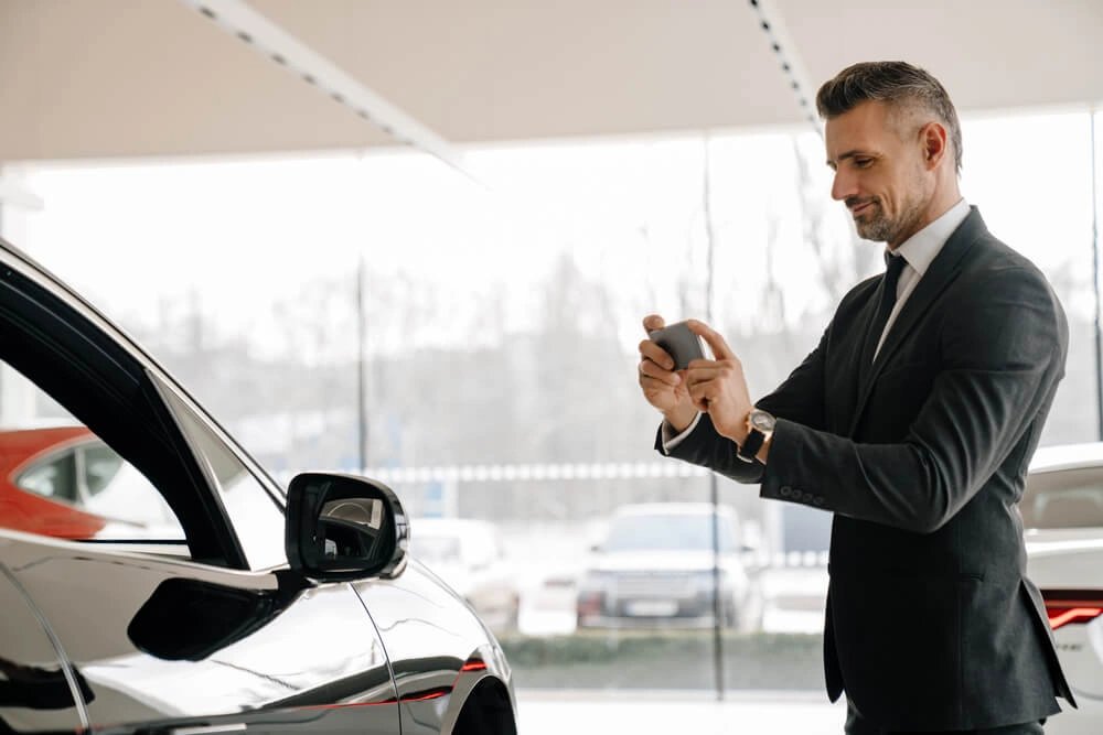 Persona tomando fotos a un carro con buena luz para publicar el anuncio de venta